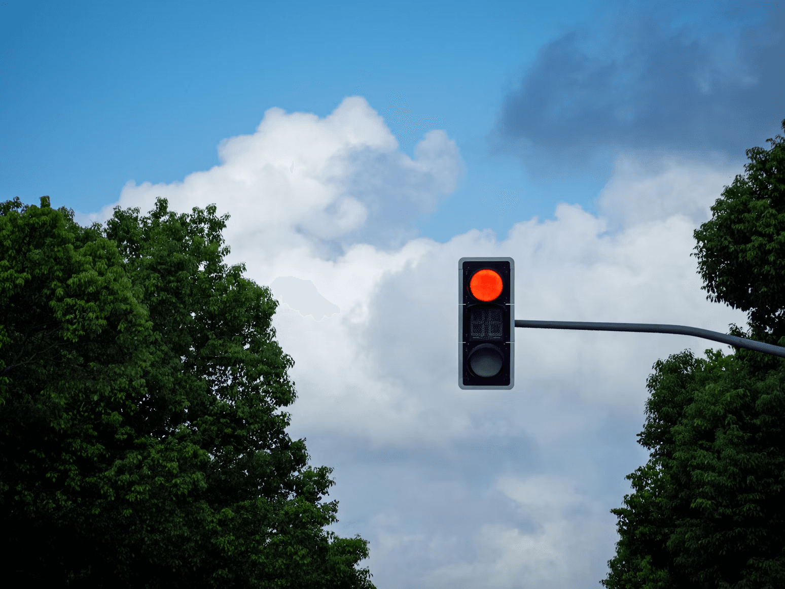 Traffic light against a cloudy sky